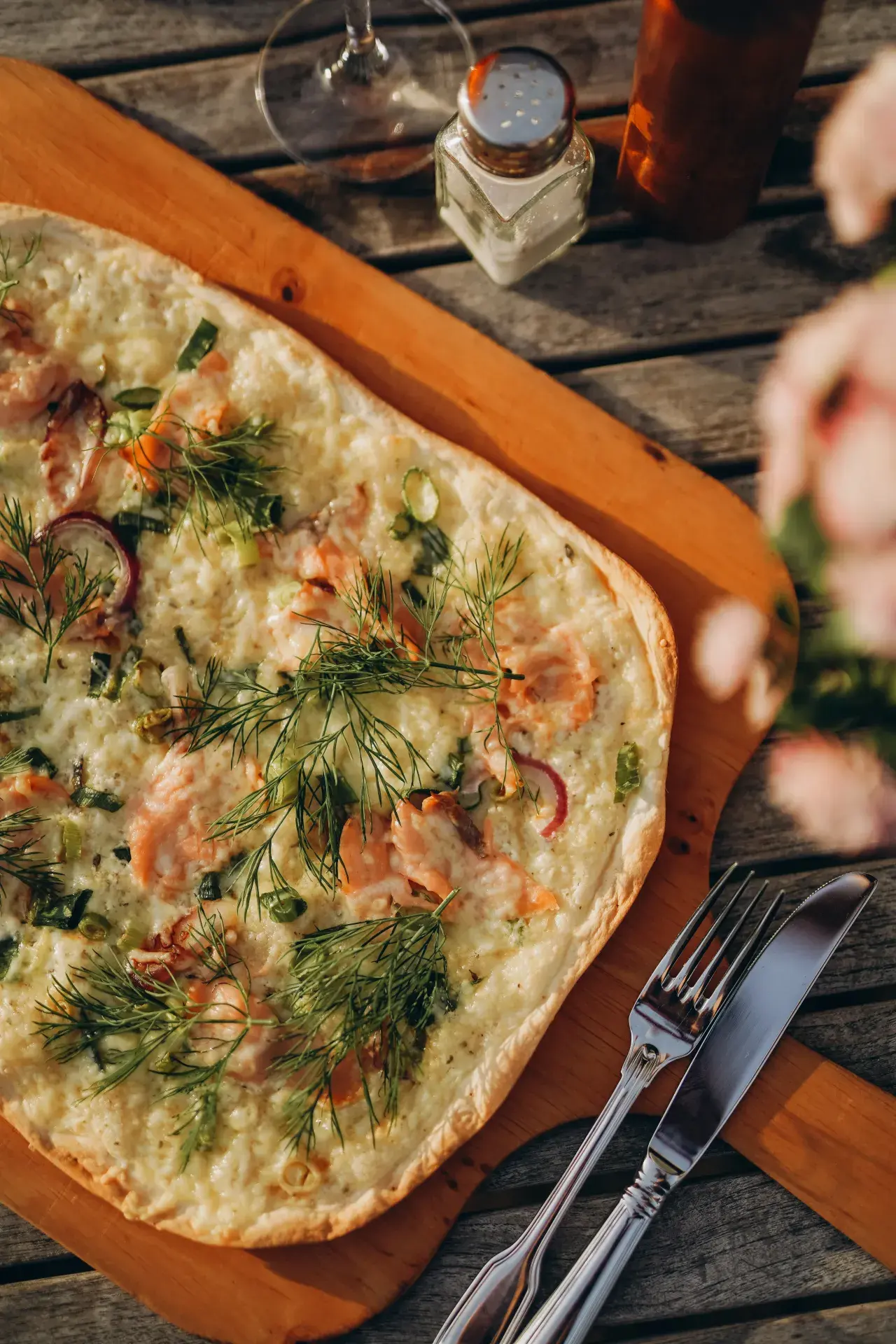 Lachs-Flammkuchen mit Dill auf einem Holzbrett