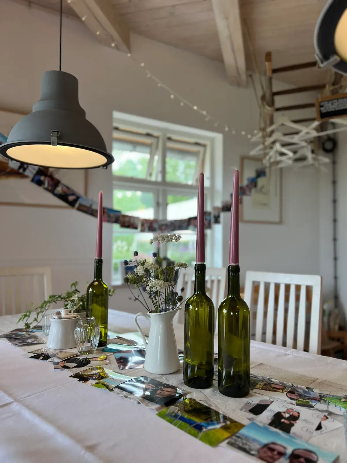 Festlich gedeckte Tafel mit Kerzen und Fotogirlande im Saal der Mühle